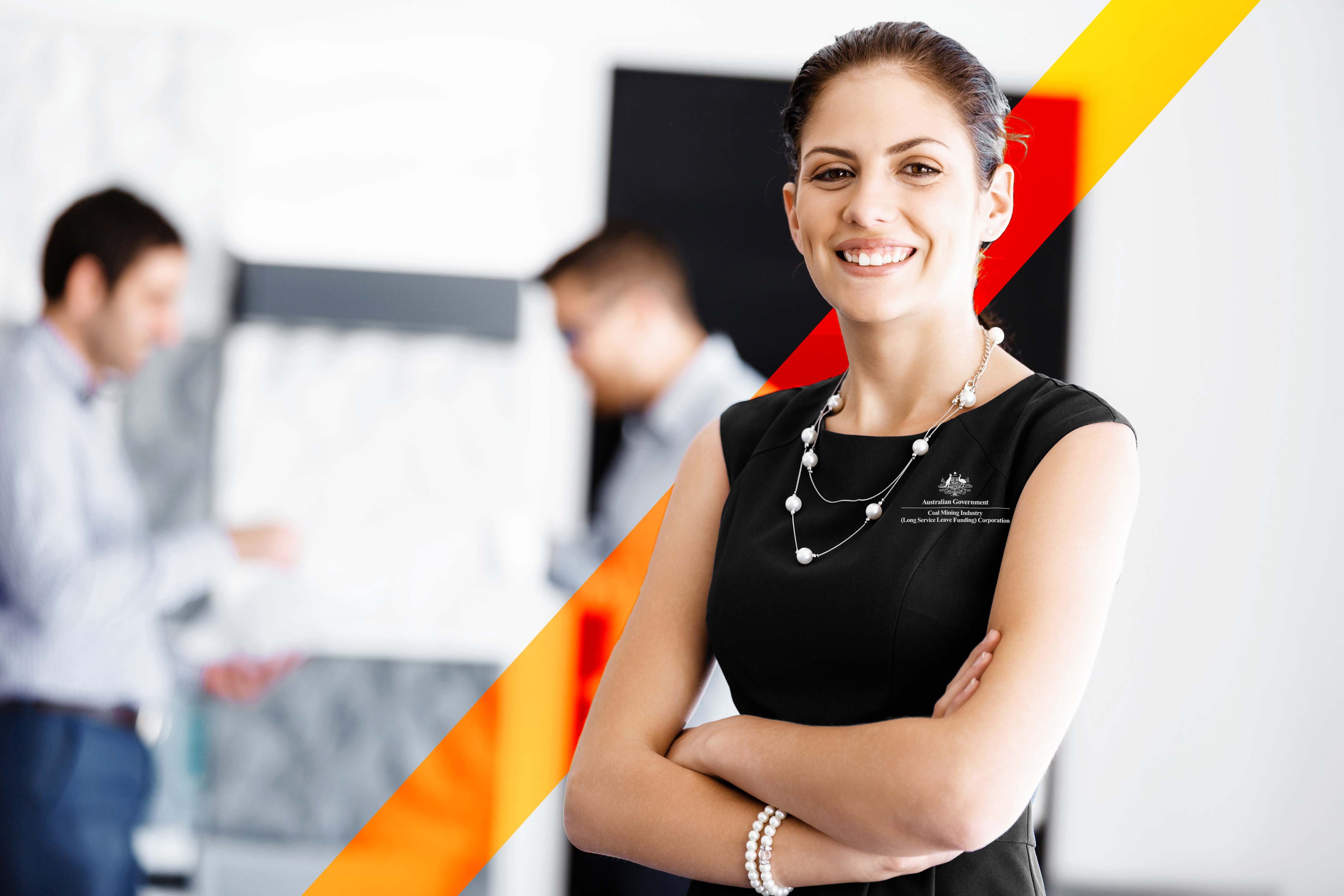 Young woman wearing a black Coal LSL dress and pear necklace, smiling at the camera with her arms crossed.